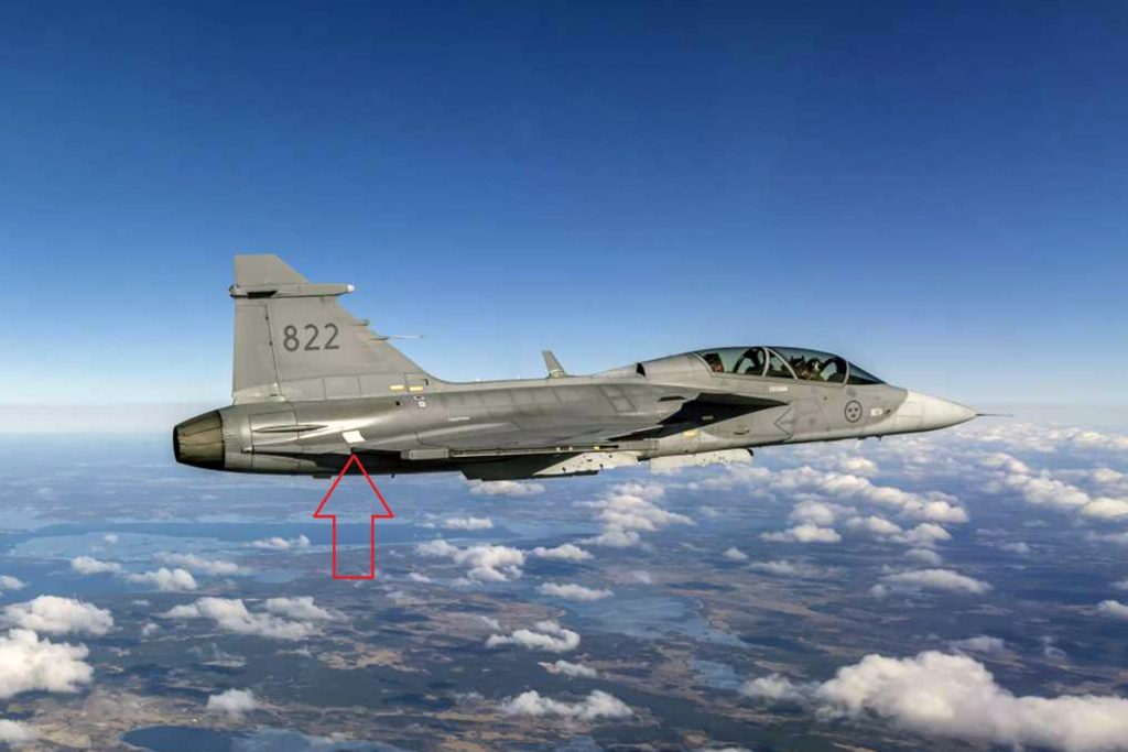 O painel prateado impresso em 3D visto na seção traseira do Gripen D, durante o primeiro voo de testes (Foto: Saab).