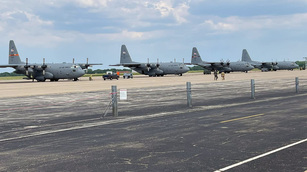 Três C-130 da USAF e o TC-60, ao fundo, estacionados no pátio da Base Aérea de Peoria, em Illinois, nos EUA.